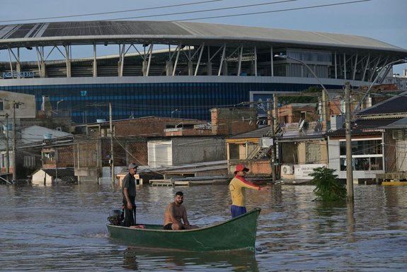 Rescuers sail by boat looking for people at the Humaita neighbourhood in Porto Alegre, Rio Grande do Sul state, Brazil, on May 7, 2024. Since the unprecedented deluge started last week, at least 85 people have died and more than 150,000 were ejected from their homes by floods and mudslides in Rio Grande do Sul state, authorities said. (Photo by NELSON ALMEIDA / AFP)<!-- NICAID(15758105) -->