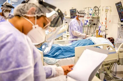 Terça-feira, 2 de março de 2021. No Centro de Tratamento Intensivo (CTI) do Hospital de Clínicas de Porto Alegre, médicos, enfermeiros, técnicos de enfermagem, fisioterapeutas e outros profissionais - inclusive realocados emergencialmente de outras áreas e especialidades - desdobram-se para dar conta do atendimento aos pacientes graves de covid-19. A capacidade é de 105 leitos, mas há 122 doentes críticos em atendimento, acomodados em leitos extras instalados no próprio CTI e também na Emergência, o que representa uma ocupação de 116%.Enquanto isso, nos 76 leitos de enfermaria do Clínicas, destinados aos pacientes menos graves, há 37 em suporte ventilatório, que deveriam estar em uma unidade de tratamento intensivo.Indexador: SILVIO AVILA<!-- NICAID(14726286) -->