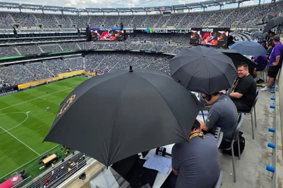 Jornalistas usam guarda chuvas para se protegerem do sol na semifinal do Mundial de Clubes 2025 entre Fluminense x Chelsea.<!-- NICAID(16076294) -->