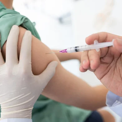 Close up of a Doctor making a vaccination in the shoulder of patient, Flu Vaccination Injection on Arm, coronavirus, covid-19 vaccine disease preparing for human clinical trials vaccination shot.<!-- NICAID(15616952) -->