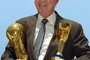 TO GO WITH AFP STORY(FILE) Four-time World Cup winner Mario Zagallo holds the Jules Rimet (R) and FIFA trophies as he poses for photographers in Rio de Janeiro, Brazil in March 2003. Zagallo won the World Cup as a player in 1958 and 1962, as a coach in 1970 and as technical director to Carlos Parreira in 1994. He also coached Brazil to the 1998 final where they lost to France.  AFP PHOTO/Antonio SCORZA/FILES (Photo by ANTONIO SCORZA / AFP)Editoria: SPOLocal: Rio de JaneiroIndexador: ANTONIO SCORZASecao: soccerFonte: AFPFotógrafo: STF<!-- NICAID(14277448) -->