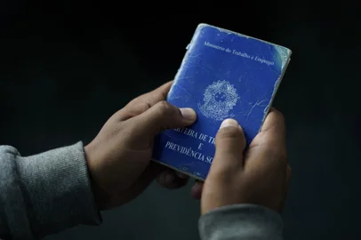 (FILES) A man holds his Brazilian working document during a weekly job fair at the Telecommunications Workers Union in Rio de Janeiro, Brazil, on June 05, 2019. Brazil's unemployment rate fell slightly in the October-December quarter to 7.4 percent, its lowest level in almost eight years, according to official figures released on January 31, 2024. (Photo by MAURO PIMENTEL / AFP)Editoria: FINLocal: Rio de JaneiroIndexador: MAURO PIMENTELSecao: economy (general)Fonte: AFPFotógrafo: STF<!-- NICAID(15665629) -->