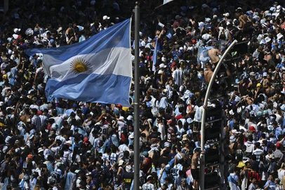 Fans of Argentina wait for the bus with Argentina's players to pass through the Obelisk to celebrate after winning the Qatar 2022 World Cup tournament in Buenos Aires on December 20, 2022. - The airplane transporting World Cup winners Argentina and their captain Lionel Messi back from Qatar arrived at the Ezeiza international airport in Buenos Aires at 2:40 am (0540 GMT) on Tuesday. On midday Tuesday they will begin a tour through the Buenos Aires city center with millions expected out in the streets on what is a public holiday. (Photo by Luis ROBAYO / AFP)Editoria: SPOLocal: Buenos AiresIndexador: LUIS ROBAYOSecao: soccerFonte: AFPFotógrafo: STF<!-- NICAID(15300059) -->