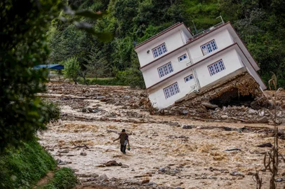 A man wades through the flood waters in the affected area of monsoon flooding in Roshi village of Nepal's Kavre district on September 30, 2024. Search and rescue teams in Nepal's capital picked through wrecked homes on September 30 after waters receded from monsoon floods that killed at least 209 people around the Himalayan republic. (Photo by PRABIN RANABHAT / AFP)Editoria: DISLocal: KavreIndexador: PRABIN RANABHATSecao: disaster (general)Fonte: AFPFotógrafo: STR<!-- NICAID(15879506) -->