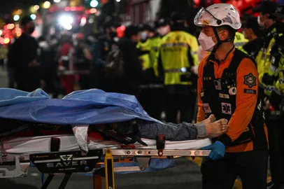 A victim of a Halloween crush, which left at least 120 people dead, is transported on a stretcher in the district of Itaewon in Seoul on October 30, 2022. - At least 120 people were killed on October 29 and some 100 were injured in a stampede in central Seoul when thousands crowded into narrow streets to celebrate Halloween, officials said. (Photo by Anthony WALLACE / AFP)<!-- NICAID(15249687) -->