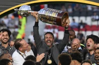 Botafogo's Portuguese head coach Artur Jorge lifts the trophy next to his players as they celebrate after winning the Copa Libertadores final football match between Brazilian teams Atletico Mineiro and Botafogo at the Mas Monumental Stadium in Buenos Aires on November 30, 2024. (Photo by Luis ROBAYO / AFP)<!-- NICAID(15925816) -->