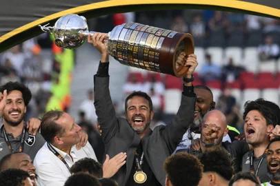 Botafogo's Portuguese head coach Artur Jorge lifts the trophy next to his players as they celebrate after winning the Copa Libertadores final football match between Brazilian teams Atletico Mineiro and Botafogo at the Mas Monumental Stadium in Buenos Aires on November 30, 2024. (Photo by Luis ROBAYO / AFP)<!-- NICAID(15925816) -->