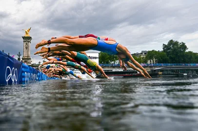 (FILES) Athletes compete in the swimming race in the Seine during the women's individual triathlon at the Paris 2024 Olympic Games in central Paris on July 31, 2024. Paris Olympics organisers have cancelled training for triathletes in the River Seine again because of poor water quality, leading to more uncertainty over whether the mixed relay will go ahead as planned on August 5, 2024. (Photo by MARTIN BUREAU / POOL / AFP)<!-- NICAID(15832120) -->