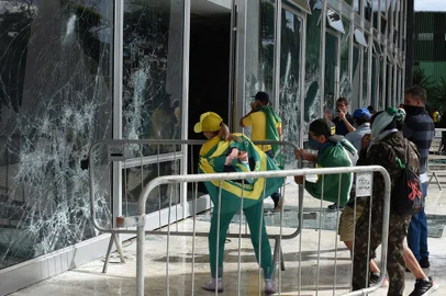Supporters of Brazilian former President Jair Bolsonaro destroy a window of the the plenary of the Supreme Court in Brasilia on January 8, 2023. - Hundreds of supporters of Brazil's far-right ex-president Jair Bolsonaro broke through police barricades and stormed into Congress, the presidential palace and the Supreme Court Sunday, in a dramatic protest against President Luiz Inacio Lula da Silva's inauguration last week. (Photo by Ton MOLINA / AFP)Editoria: WARLocal: BrasíliaIndexador: TON MOLINASecao: demonstrationFonte: AFPFotógrafo: STR<!-- NICAID(15315597) -->
