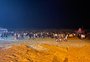 Jovens fazem festa nas areias de Atlântida na madrugada