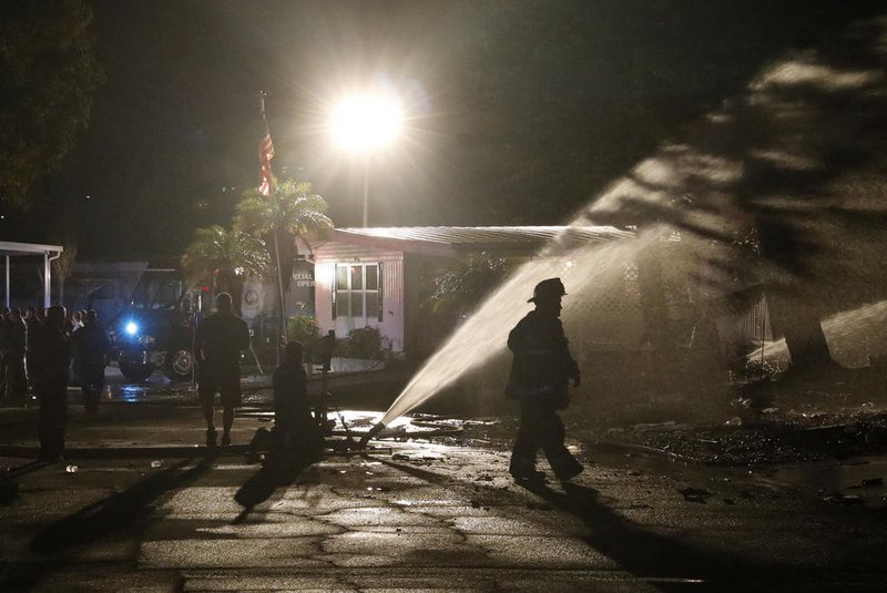 Firefighters work to put out a fire after a small plane crashed into the Bayside Waters mobile home park in Clearwater, Florida, on February 1, 2024. There are "several fatalities both from the aircraft and within the mobile home, Fire Chief Scott Ehlers said. (Photo by OCTAVIO JONES / AFP)<!-- NICAID(15667868) -->