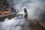 (FILES) A member of a health brigade fumigates a street against the dengue virus at a shanty town on the hills of San Juan de Lurigancho district, Lima on May 11, 2023. The Peruvian government will declare a state of health emergency in 20 of its 25 regions as of February 27, 2024, due to a strong outbreak of dengue fever, the chief of staff announced on February 26. (Photo by Cris BOURONCLE / AFP)<!-- NICAID(15690536) -->