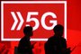 People walk past a 5G hotspot sign at the Mobile World Congress (MWC) in Barcelona on February 26, 2019. - Phone makers will focus on foldable screens and the introduction of blazing fast 5G wireless networks at the world's biggest mobile fair as they try to reverse a decline in sales of smartphones. (Photo by Josep LAGO / AFP)Editoria: FINLocal: BarcelonaIndexador: JOSEP LAGOSecao: telecommunication equipmentFonte: AFPFotógrafo: STR<!-- NICAID(14902915) -->