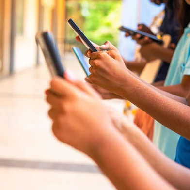 Close up shot, group of children hands busy using smartphone at school corridor - concept of social media, playing games, technology and education.<!-- NICAID(16100876) -->