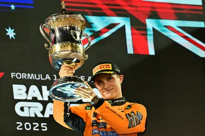 McLaren's Australian driver Oscar Piastri lifts the trophy on podium after winning the Bahrain Formula One Grand Prix at the Bahrain International Circuit in Sakhir on April 13, 2025. (Photo by Giuseppe CACACE / AFP)<!-- NICAID(16016462) -->