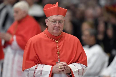 (FILES) Bishop of Dallas Kevin Joseph Farrell walks after kneeling before Pope Francis to pledge allegiance and become cardinal, on November 19, 2016 during a consistory at Peter's basilica. Pope Francis has named 17 new cardinals, 13 of them under age 80 and thus eligible to vote in a conclave to elect his successor. Following the Pope's passing, the day-to-day running of the tiny Vatican City state will be handled by the camerlengo, a senior cardinal, currently Dublin-born Kevin Farrell. (Photo by TIZIANA FABI / AFP)<!-- NICAID(16020849) -->