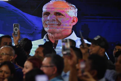 An LCD screen displays a portrait of Honduras' presidential candidate Nasry Asfura of the National Party, as supporters celebrate after the National Electoral Council (CNE) declares him the winner of the Honduras' Presidential Election in Tegucigalpa on December 24, 2025. Conservative businessman Nasry Asfura, backed by US President Donald Trump, was officially proclaimed the new president of Honduras on December 24, 2025, three weeks after an election marked by a narrow margin of victory and allegations of fraud. (Photo by Orlando SIERRA / AFP)<!-- NICAID(16193350) -->