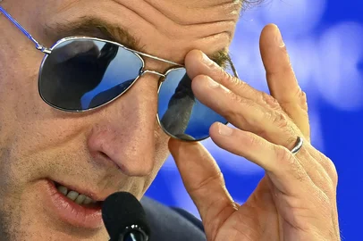 FABRICE COFFRINI / AFP France's President Emmanuel Macron adjusts his sunglasses as he delivers a speech during the World Economic Forum (WEF) annual meeting in Davos on January 20, 2026. The World Economic Forum takes place in Davos from January 19 to January 23, 2026. (Photo by Fabrice COFFRINI / AFP)<!-- NICAID(16207545) -->