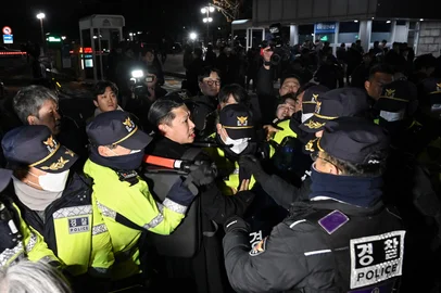 Police attempt to hold back people trying to enter the National Assembly in front of the main gate of the National Assembly in Seoul, South Korea on December 3, 2024, after President Yoon Suk Yeol declared emergency martial law. South Korea's President Yoon Suk Yeol on December 3 declared emergency martial law, saying the step was necessary to protect the country from "communist forces" amid parliamentary wrangling over a budget bill. (Photo by JUNG YEON-JE / AFP)<!-- NICAID(15927511) -->