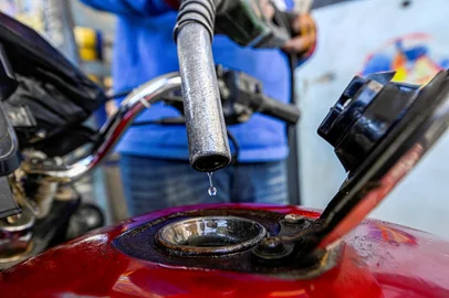 A worker fills the tank of a motorcycle at a petrol station in Giza on March 10, 2026. Egypt raised domestic fuel prices by up to 30 percent on March 10, blaming "exceptional" global energy pressures caused by the Middle East war, which has disrupted oil supplies and shipping routes. (Photo by Khaled DESOUKI / AFP)Editoria: FINLocal: CairoIndexador: KHALED DESOUKISecao: energy and resourceFonte: AFPFotógrafo: STF<!-- NICAID(16242301) -->
