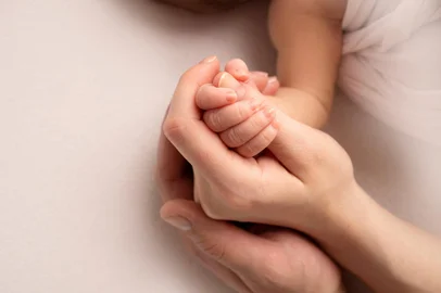 The hand of a sleeping newborn in the hand of mother and father close-up. Tiny fingers of a newborn. The family is holding hands. Studio macro photography. Concepts of family and love.The hand of a sleeping newborn in the hand of mother and father close-up. Tiny fingers of a newborn. The family is holding hands. Studio macro photography. Concepts of family and love. Fonte: 483478935<!-- NICAID(15661466) -->
