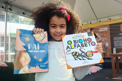 Ana Júlia Aurélio Santana, de 5 anos, mostra os livros que ganhou da mãe, Querubina Aurélio, no III Festival Internacional do Leitor Quindim, em Caxias do Sul.<!-- NICAID(16346864) -->