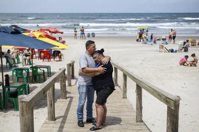 Capão da Canoa, RS, Brasil, 18-02-2025: O casal Faruk Lindemann e Gislaine Teresinha Chiabotto Adolfo na beira da praia em Capão da Canoa, no Litoral Norte. Eles moravam em Nova Santa Rita e mudaram para o Litoral durante a pandemia, principalmente por questões de saúde de Gislaine, considerada grupo de risco para Covid-19, e, depois, resolveram seguir morando em Capão da Canoa. Foto: Mateus Bruxel / Agência RBSIndexador: MATEUS BRUXEL<!-- NICAID(15983785) -->