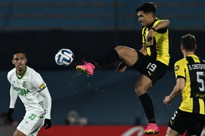 Peñarol's forward Matias Arezo (C) and America MG's defender Eder fight for the ball during the Copa Sudamericana group stage second leg football match between Uruguay's Peñarol and Brazil's America Mineiro, at the Centenario stadium in Montevideo on June 29, 2023. (Photo by Pablo PORCIUNCULA / AFP)Editoria: SPOLocal: MontevideoIndexador: PABLO PORCIUNCULASecao: soccerFonte: AFPFotógrafo: STF<!-- NICAID(15536967) -->
