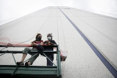 PORTO ALEGRE, RS, BRASIL, 26-11-2021: A suiça Mona Caron e o paulista Mauro Neri ao lado do predio do Daer. Os artistas vao pintar um painel de grandes dimensões na lateral da sede da instituição. (Foto: Mateus Bruxel / Agencia RBS)Indexador: Mateus Bruxel<!-- NICAID(14952220) -->
