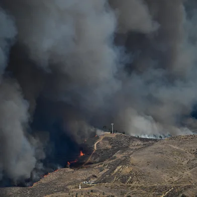 As chamas correm colina acima enquanto a coluna de fumaça do novo incêndio Hughes enche o céu em Castaic, um bairro noroeste de Los Angeles, Califórnia, em 22 de janeiro de 2025. Um novo incêndio florestal irrompeu ao norte de Los Angeles em 22 de janeiro, explodindo em tamanho e provocando milhares de ordens de evacuação em uma região já cambaleante pelos efeitos de grandes incêndios.<!-- NICAID(15959661) -->