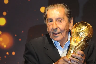 Former footballer Alcides Ghiggia, 86, the last survivor of Uruguay's shock win over Brazil in the deciding match of the 1950 World Cup at the Maracana Stadium, holds the FIFA World Cup trophy during its exhibition in Montevideo as part of a world tour ahead of the Brazil 2014 World Cup tournament, on January 16, 2014.   AFP PHOTO/ Miguel ROJO (Photo by MIGUEL ROJO / AFP)Editoria: SPOLocal: MontevideoIndexador: MIGUEL ROJOSecao: soccerFonte: AFP<!-- NICAID(16080311) -->