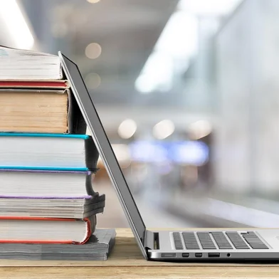 Stack of books with laptop on wooden tableFonte: 317601158<!-- NICAID(15404817) -->