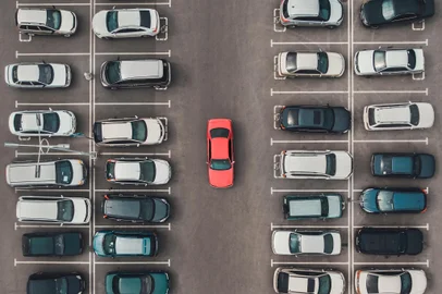 Top view of the crowded Parking lot with quadcopter or drone. Original bright automobile among the grey of mediocre cars. Parking space search, No parking spaceConceito de vaga, estacionamento - Foto: diy13/stock.adobe.comFonte: 226723578<!-- NICAID(15917028) -->