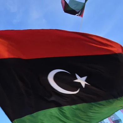 A man waves the Libyan flag during a march to commemorate the 14th anniversary of the uprising that toppled longtime strongman Muammar Kadhafi in Tajura, on the outskirts of Tripoli on February 16, 2025. (Photo by AFP) bandeira libia<!-- NICAID(15979890) -->