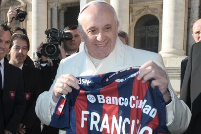 This handout picture released on December 18, 2013 by the Vatican press office shows Pope Francis (R) holding the jersey of San Lorenzo's Argentinian football club as he poses with San Lorenzo's Argentinian football team president Matías Lammens (2ndL) and Argentinian television presenter Marcelo Tinelli (C)after his general audience at St Peter's square at the Vatican. San Lorenzo's players won the Argentina's first division football Championship at Jose Amalfitani stadium in Buenos Aires, Argentina, on December 15, 2013.  AFP PHOTO / OSSERVATORE ROMANO/HO  RESTRICTED TO EDITORIAL USE - MANDATORY CREDIT "AFP PHOTO / OSSERVATORE ROMANO" - NO MARKETING NO ADVERTISING CAMPAIGNS - DISTRIBUTED AS A SERVICE TO CLIENTSEditoria: RELLocal: Vatican CityIndexador: -Secao: religious leaderFonte: OSSERVATORE ROMANOFotógrafo: -<!-- NICAID(10069337) -->