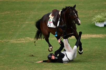 Brazil's Maria Ieda Chaves Guimaraes falls as she competes in the women's individual riding show jumping modern pentathlon during the Tokyo 2020 Olympic Games at the Tokyo Stadium in Tokyo on August 6, 2021. (Photo by Pedro PARDO / AFP)<!-- NICAID(14855803) -->
