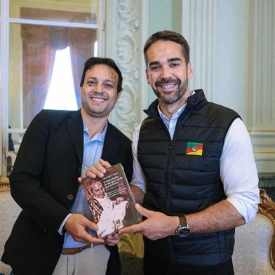 Christopher Goulart entrega seu livro "E Manchado de Sangue Terás que Crescer: uma Vida de Lutas" para o governador Eduardo Leite.<!-- NICAID(16102882) -->