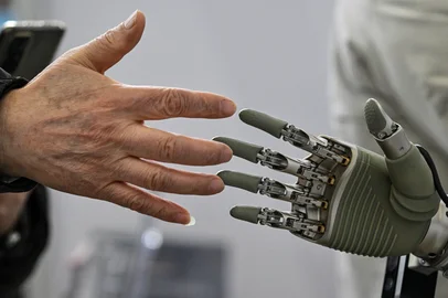 A man touches a robotic hand from OY Motion during the Global Developer Conference, organised by the Shanghai AI Industry Association, in Shanghai on February 21, 2025. (Photo by Hector RETAMAL / AFP)Editoria: FINLocal: ShanghaiIndexador: HECTOR RETAMALSecao: computing and information technoFonte: AFPFotógrafo: STF<!-- NICAID(15981339) -->