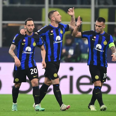 Inter Milan's Turkish midfielder #20 Hakan Calhanoglu, Inter Milan's Austrian forward #08 Marko Arnautovic and Inter Milan's Argentine forward #10 Lautaro Martinez celebrate the team's first goal during the UEFA Champions League last 16 first leg football match Inter Milan vs Atletico Madrid at the San Siro stadium in Milan on February 20, 2024. (Photo by Marco BERTORELLO / AFP)<!-- NICAID(15684976) -->