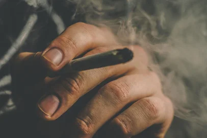 Smoke on a black background. Concepts of medical marijuana use and legalization of the cannabis. cannabis weed A man smokes, a joint and a lighter in his hands.Smoke on a black background. Concepts of medical marijuana use and legalization of the cannabis. cannabis weed A man smokes, a joint and a lighter in his hands.Fonte: 309281022<!-- NICAID(15191874) -->