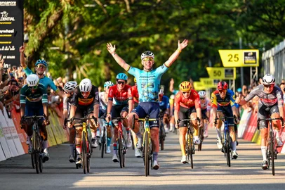 Britain's Mark Cavendish (C) celebrates as he crosses the finish line during the third Tour de France Singapore Criterium race in Singapore on November 10, 2024. 39-year-old Cavendish, the record stage winner on the Tour with 35, competes in the final race of his storied career in Singapore. (Photo by Roslan RAHMAN / AFP)<!-- NICAID(15910876) -->