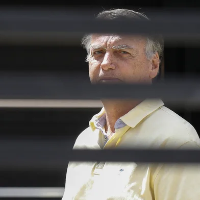 Former Brazilian President Jair Bolsonaro gestures from his residence in Brasilia on September 3, 2025. Brazil's Supreme Court on Tuesday began verdict deliberations in the trial of former president Jair Bolsonaro, who is accused of plotting a coup to attempt to retain power after he lost the 2022 election. (Photo by Sergio Lima / AFP)Editoria: POLLocal: BrasíliaIndexador: SERGIO LIMASecao: trialsFonte: AFPFotógrafo: STR<!-- NICAID(16116384) -->