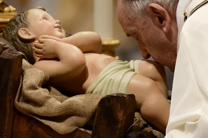 Pope Francis kisses a figurine of baby Jesus during the Christmas Eve mass at St Peter's Basilica in the Vatican, on December 24, 2021. (Photo by Filippo MONTEFORTE / AFP)<!-- NICAID(14976543) -->