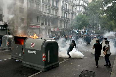 Football fans set garbage containers on fire during a protest of pensioners against the government of President Javier Milei in Buenos Aires on March 12, 2025. (Photo by Luis ROBAYO / AFP)<!-- NICAID(15994310) -->
