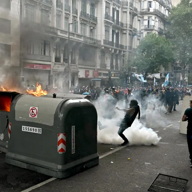 Football fans set garbage containers on fire during a protest of pensioners against the government of President Javier Milei in Buenos Aires on March 12, 2025. (Photo by Luis ROBAYO / AFP)<!-- NICAID(15994310) -->