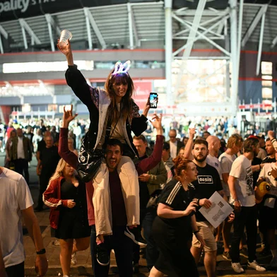 Fans of British rock band Oasis react outside the Principality Stadium in Cardiff on July 4, 2025, after attending the opening concert of their highly anticipated reunion tour nearly 16 years after last performing together. Two consecutive nights of concerts at the Principality Stadium in the Welsh capital mark the start of a 41-date run of gigs spanning the world. (Photo by Oli SCARFF / AFP)<!-- NICAID(16073998) -->