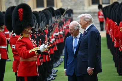Britain's King Charles III (C) and US President Donald Trump (R) talk with a Coldstream Guardsman as they inspect the guard of honour during a ceremonial welcome in the Quadrangle at Windsor Castle, in Windsor, on September 17, 2025, during the US president's second State Visit. US President Donald Trump arrived in Britain for an unprecedented second State Visit, with the UK government rolling out a royal red carpet welcome to win over the mercurial leader. (Photo by ANDREW CABALLERO-REYNOLDS / AFP)<!-- NICAID(16126284) -->