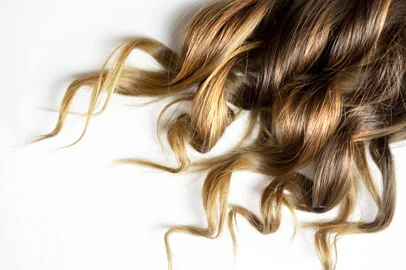 long brown curly hair on white isolated backgroundpiece of brown curly shiny hair on white isolated backgroundFonte: 294181967<!-- NICAID(14395020) -->