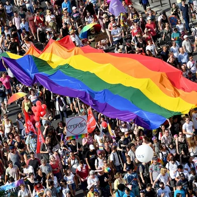 (FILES) In this file photo taken on July 06, 2019 people march with their giant rainbow flag during the lesbian, gay, bisexual and transgender (LGBT) Pride Parade from the parliament building in downtown Budapest. - Hungary's Prime Minister Viktor Orban said on July 21, 2021 that a referendum would be held to gauge domestic support for a controversial LGBTQ law, after the European Commission launched legal action against Budapest over the measure. (Photo by ATTILA KISBENEDEK / AFP)<!-- NICAID(14840460) -->