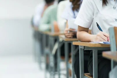 Students Taking Exam in Classroom Setting. Students in uniforms are seated in a classroom, writing answers during an exam, highlighting focus and academic testing.Conceito de sala de aulas - Foto: EduLife Photos/stock.adobe.comIndexador: Sengchoy InthachackFonte: 1001290688<!-- NICAID(15911733) -->